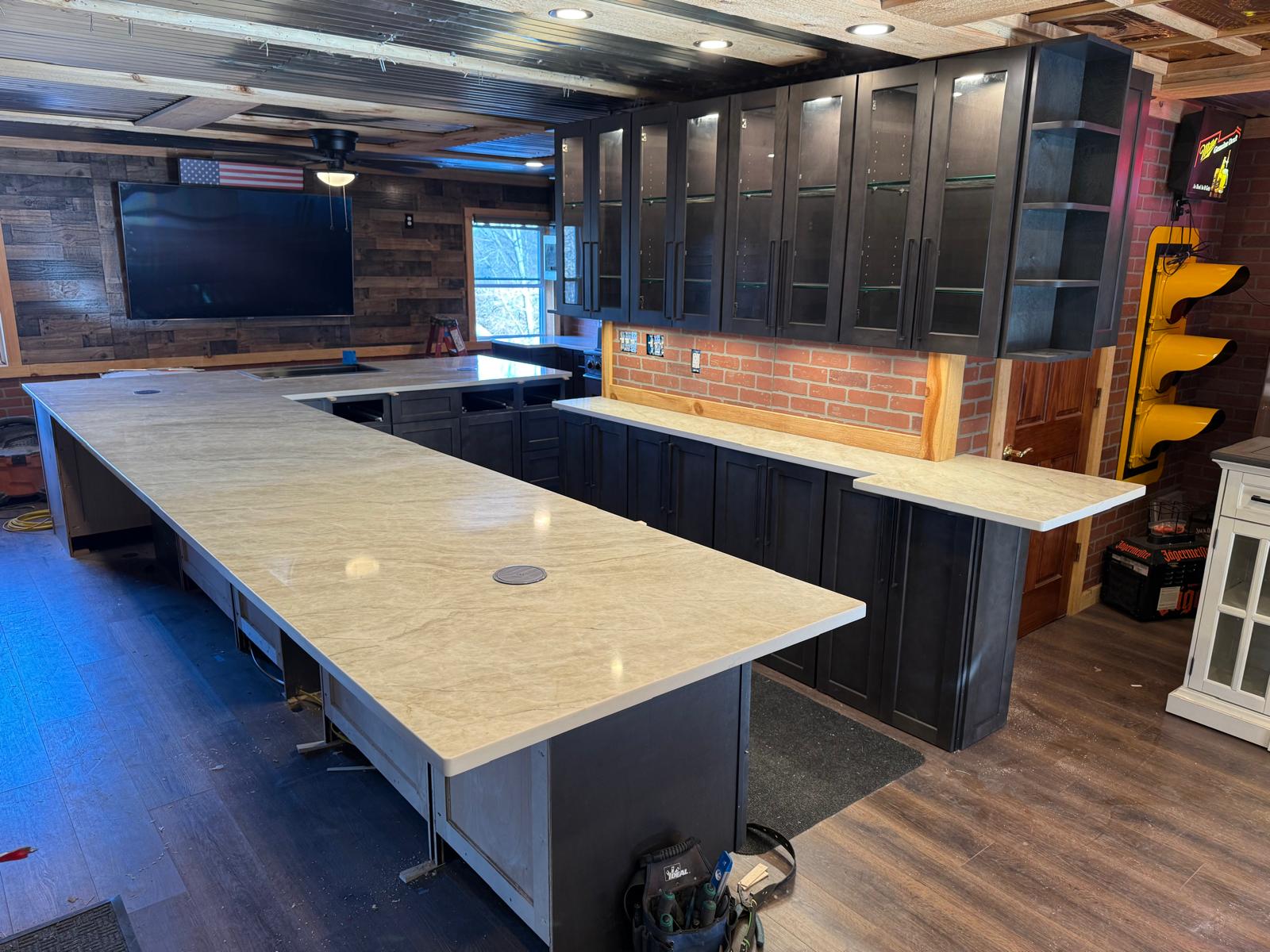 Custom home basement bar with dark cabinets and quartz countertops
