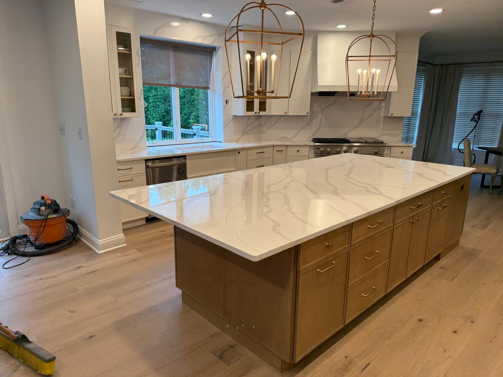Modern kitchen with custom wood grain cabinets and gold vein quartz countertops